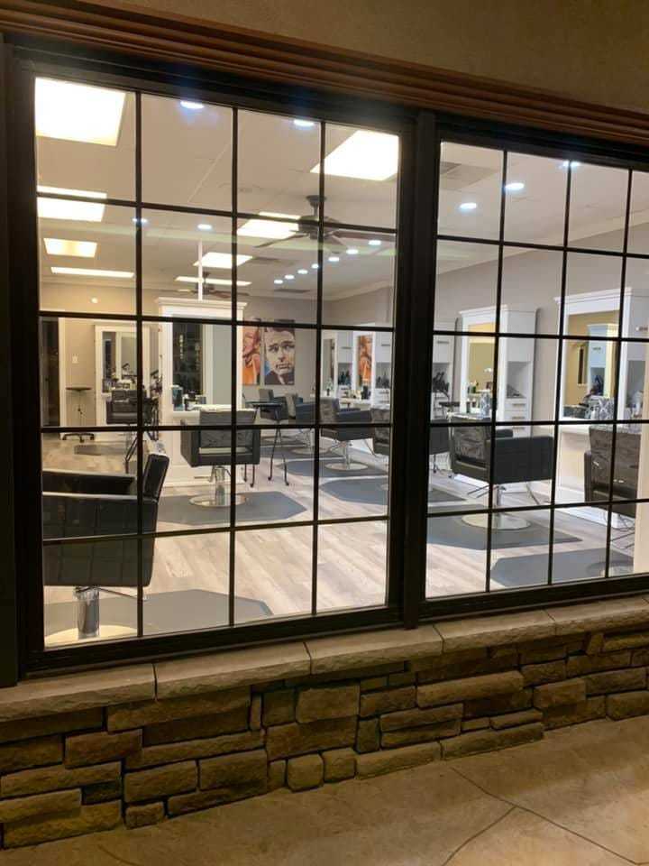 A modern salon interior seen through large windows at night.