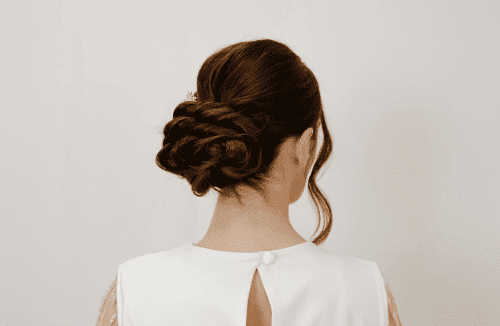 Elegant bridal updo hairstyle with braided details, viewed from the back.