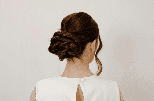 Elegant bridal updo hairstyle with braided details, viewed from the back.
